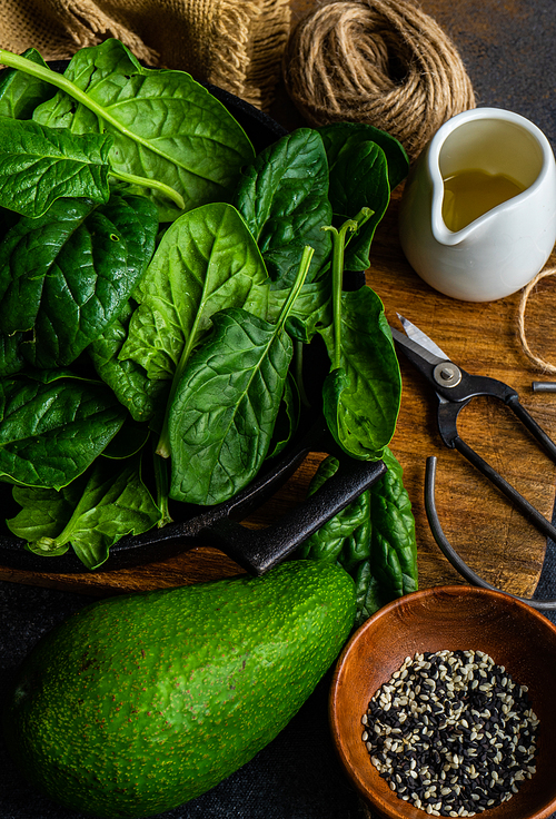 Organic food concept with fresh baby spinach leaves and avocado for healthy salad cooking