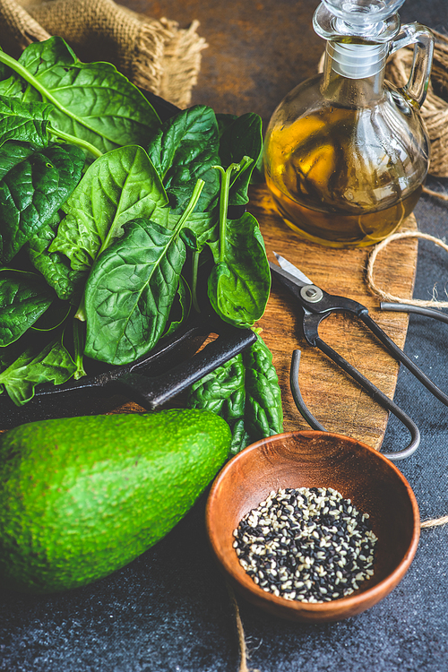 Organic food concept with fresh baby spinach leaves and avocado for healthy salad cooking