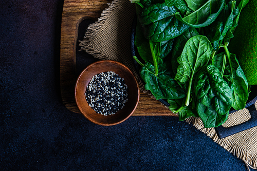 Organic food concept with fresh baby spinach leaves and avocado for healthy salad cooking