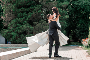 loving couple of newlyweds standing in city Park. holidays and events
