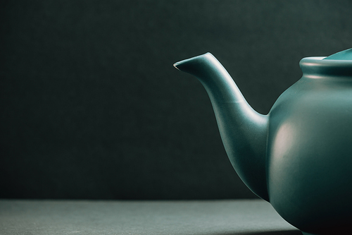 A teapot showing from the right corner over a dark background