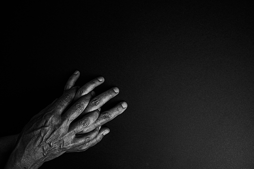 Two old hands in black and white poking out from one corner