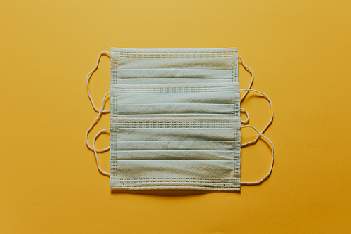 Bunch of medical masks over a yellow background