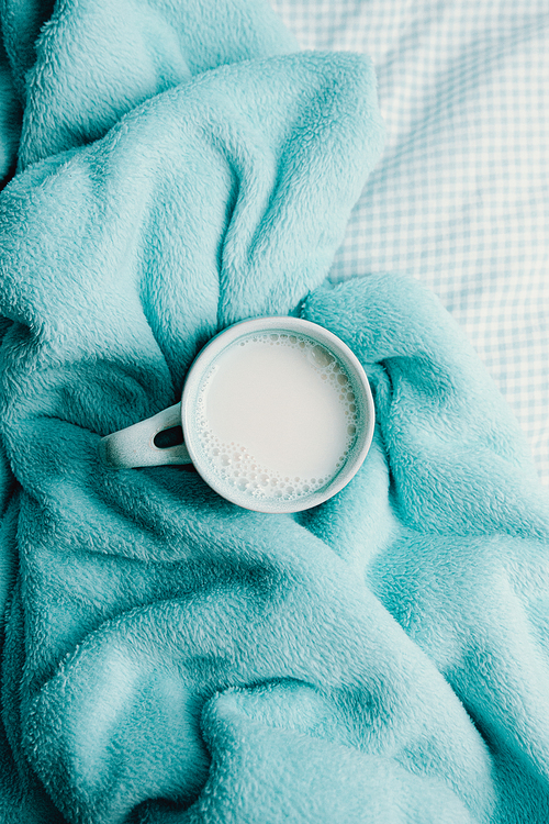 A cup of milk over a cozy blanket