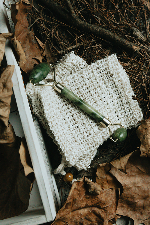 A jade roller over autumnal leaves mockup with copy space