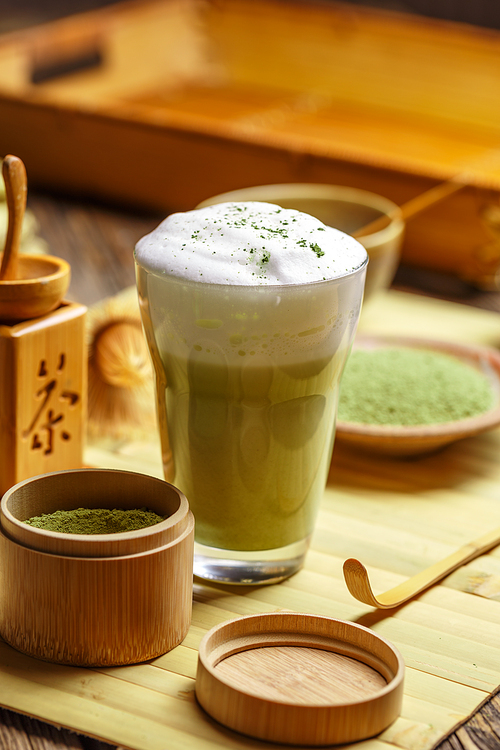 Glass of matcha green tea frappe on wooden table