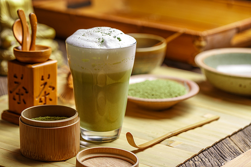 Still life with Japanese matcha accessories and matcha tea latte in glass