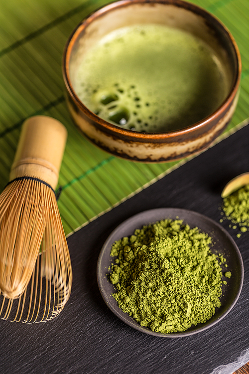 Matcha fine powder and green tea with whisk