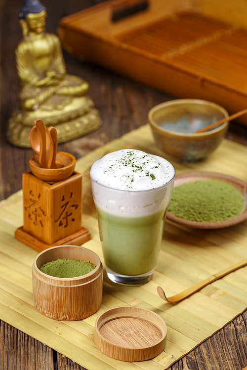 Still life with Japanese matcha accessories and matcha tea latte in glass