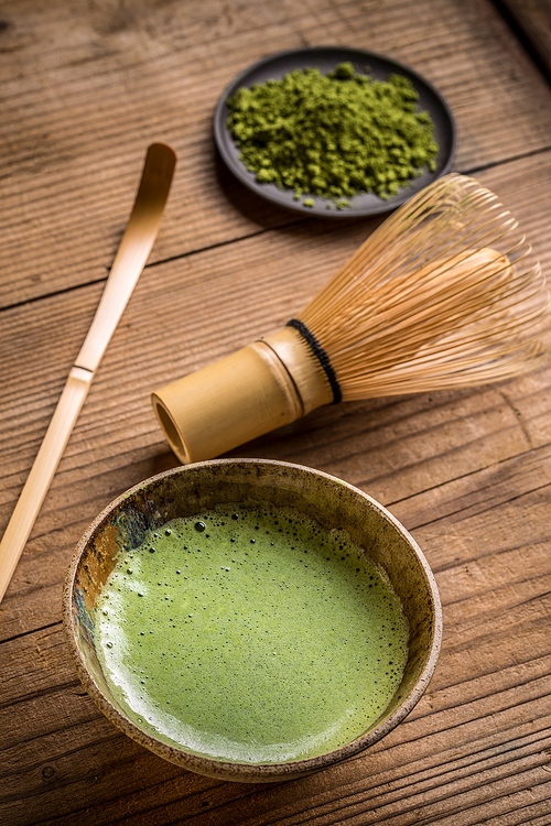 Still life with Japanese matcha accessories and green tea in bowl