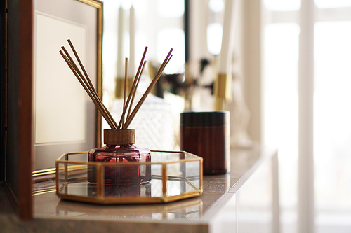 Aroma sticks with glass stand over bright background. Home fragrance.