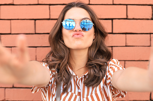 Optimistic smiling girl posing in front of old wall background