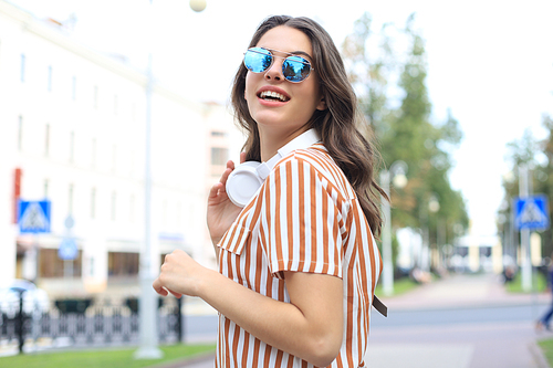 Smiling happy young beautiful woman walking outdoors