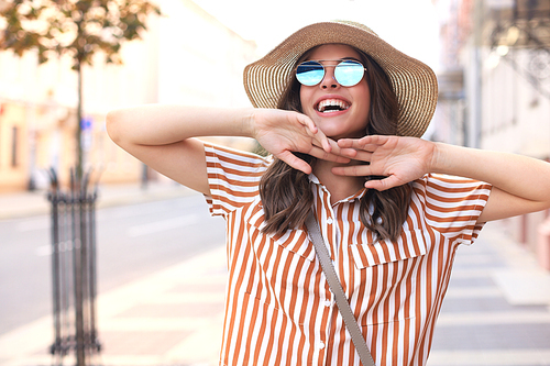 Portrait fashion woman is posing in the city, summer street fashion. Laughing and smiling portrait