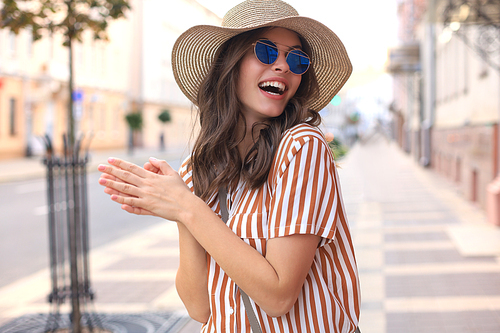 Portrait fashion woman is posing in the city, summer street fashion. Laughing and smiling portrait