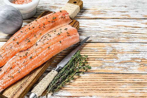 Raw salmon or trout sea fish fillet with spices and herbs. White wooden background. Top view. Copy space.