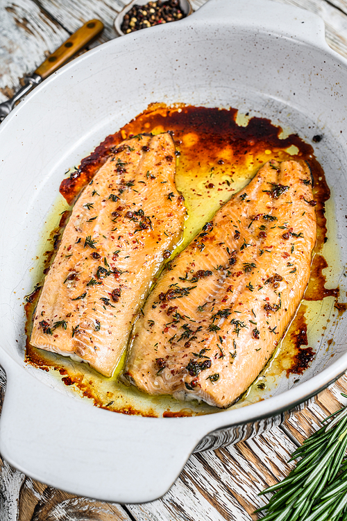 Oven Baked salmon or trout fillet. White woodenbackground. Top view.