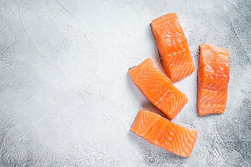 Raw salmon fillet steak on kitchen table. White background. Top view. Copy space.