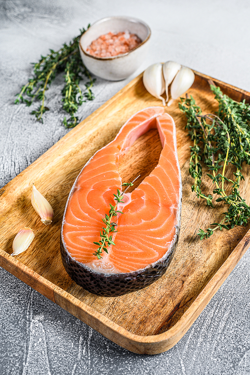 Fresh raw salmon steak with salt. Gray background. Top view.