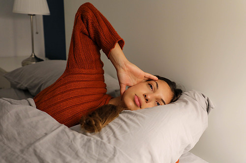 Young woman on bed suffering headache insomnia for migraine stress