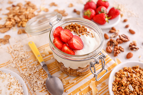 Homemade granola with yogurt and fresh strawberries in glass jar