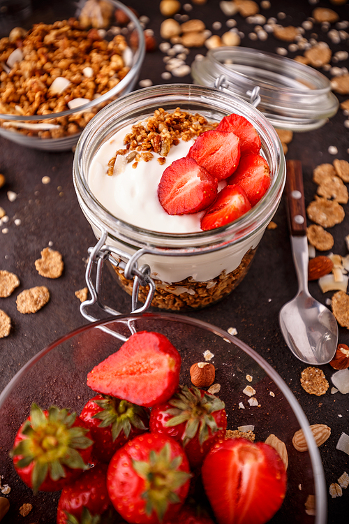 Oat granola breakfast cereal served with yogurt and fresh strawberries