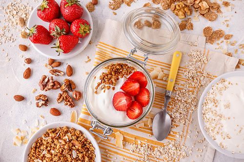 Healthy breakfast in a glass jar with homemade baked granola, fresh strawberries and yogurt