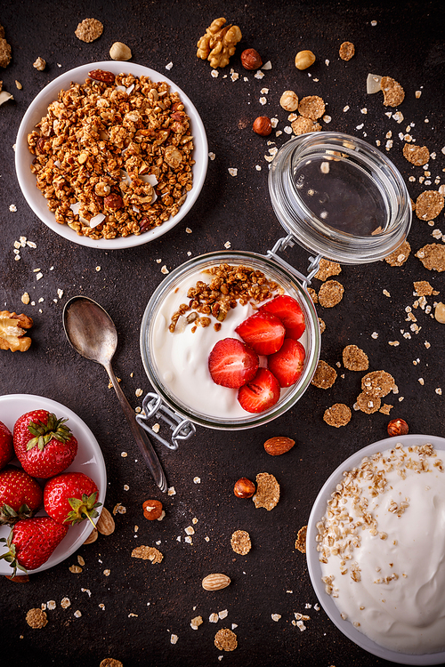 Top view of homemade granola with yogurt and fresh strawberries