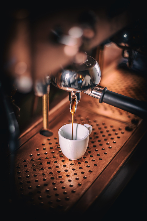 Professional espresso machine pouring strong looking fresh coffee into a cup