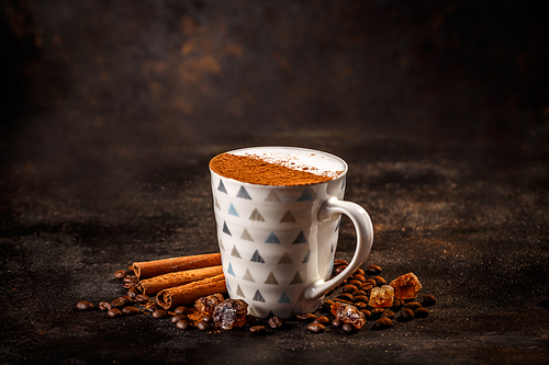 Mug of cappuccino coffee with cinnamon powder on milk foam