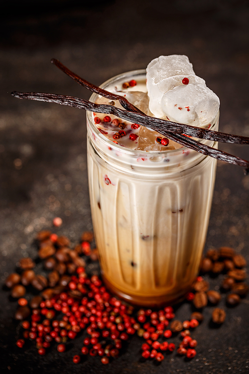 Summer drink iced coffee in glass spiced with pink peppercorn and vanilla