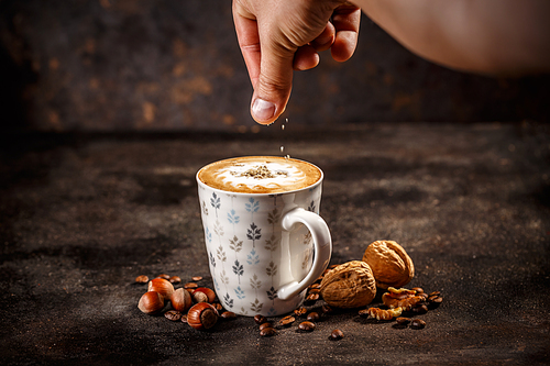 Hazelnut and walnut flavored coffee latte on vintage dark background