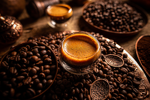 Espresso shot and coffee beans, dark toned background