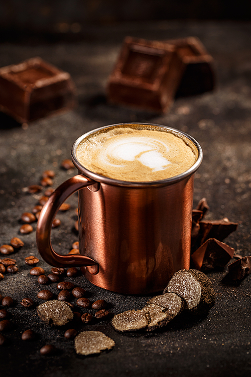 Truffle and chocolate flavored coffee latte on vintage dark background