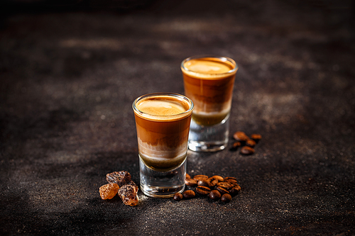 Coffee cocktail with liquor in shot glasses on a dark vintage background