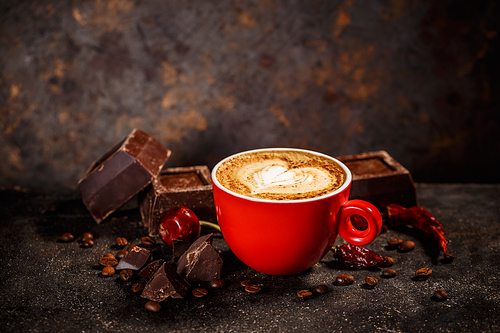 Chili and chocolate flavored coffee on vintage dark background