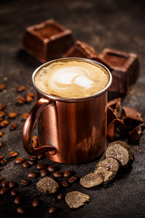 Truffle and chocolate flavored coffee latte on dark background