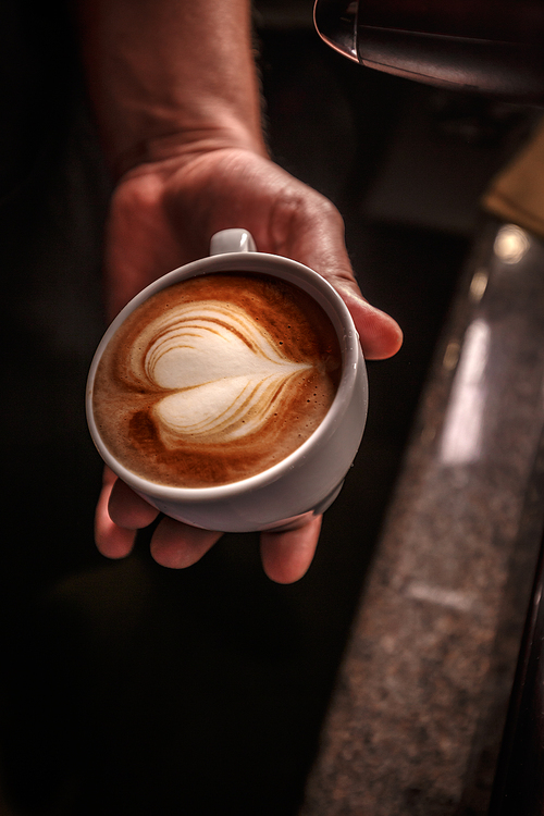 Barista create latte art in coffee shop. Coffee service concept