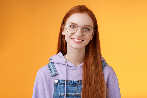 Lifestyle. Charming smart cute female freelancer order coffee working cafe standing overalls glasses hoodie smiling delighted talking casually barista orange background have happy relaxing day feel joyful.