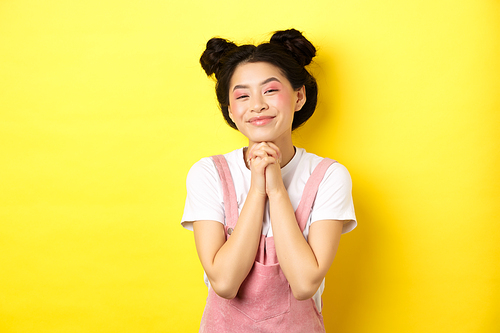 Stylish asian girl with bright makeup, say thank you, smiling grateful, standing happy on yellow background.