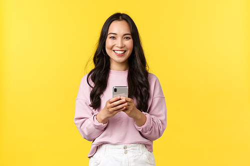 People emotions, lifestyle leisure and beauty concept. Smiling attractive young 20s woman using mobile phone. Girl making order from online shop using smartphone or using carsharing app.