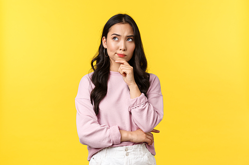 People emotions, lifestyle and fashion concept. Serious-looking complicated asian woman thinking, frowning and looking top left corner with thoughtful expression, making choice.