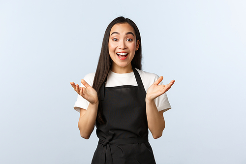 Coffee shop, small business and startup concept. Rejoicing attractive female barista clap hands amused, smiling hear good news, glad for you. Happy cheerful girl working in cafe, wear black apron.