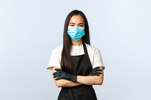 Covid-19 pandemic, social distancing, small business and preventing virus concept. Confident cute asian barista, cafe shop staff protect clients, use medical masks and gloves, cross arms chest.