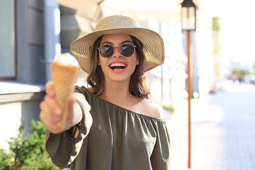 Happy attractive girl enjoying an ice cream while walking outdoor