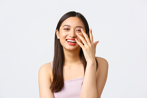 Beauty, fashion and people emotions concept. Close-up portrait of pretty smiling asian woman laughing coquettish, having fun at celebration event, enjoying party, standing white background.