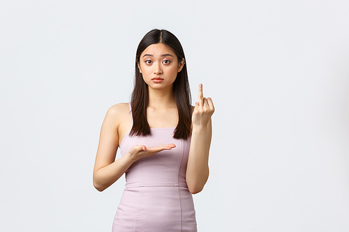 Luxury women, party and holidays concept. Asian girlfriend in evening dress complaining at boyfriend, showing ring without fingers, want to get married, standing white background.