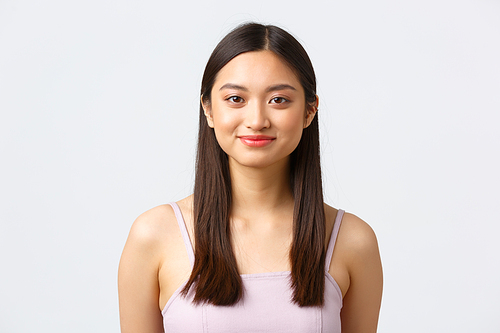 Beauty, fashion and people emotions concept. Close-up portrait of beautiful asian girl in dress smiling happy camera, looking cute and standing over white background.