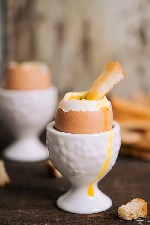 The yolk flows from boiled egg on toast