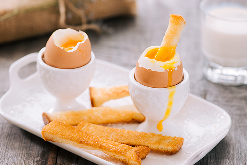 delicious breakfast with boiled eggs and crispy toasts, horizontal, closeup